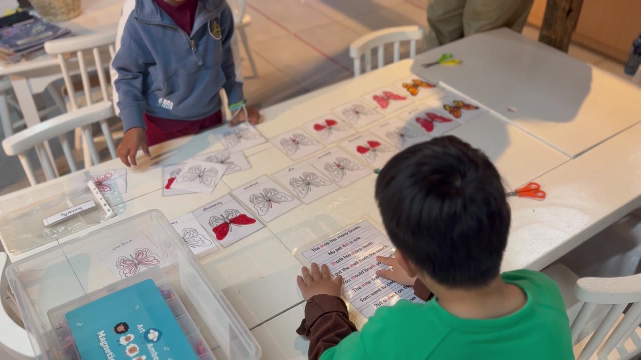 Children practising butterfly sight-word reading at the classroom table